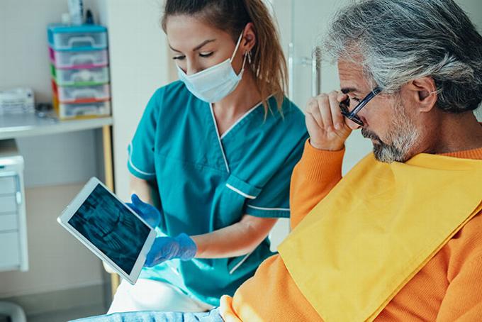 Man looking over xrays with dental nurse